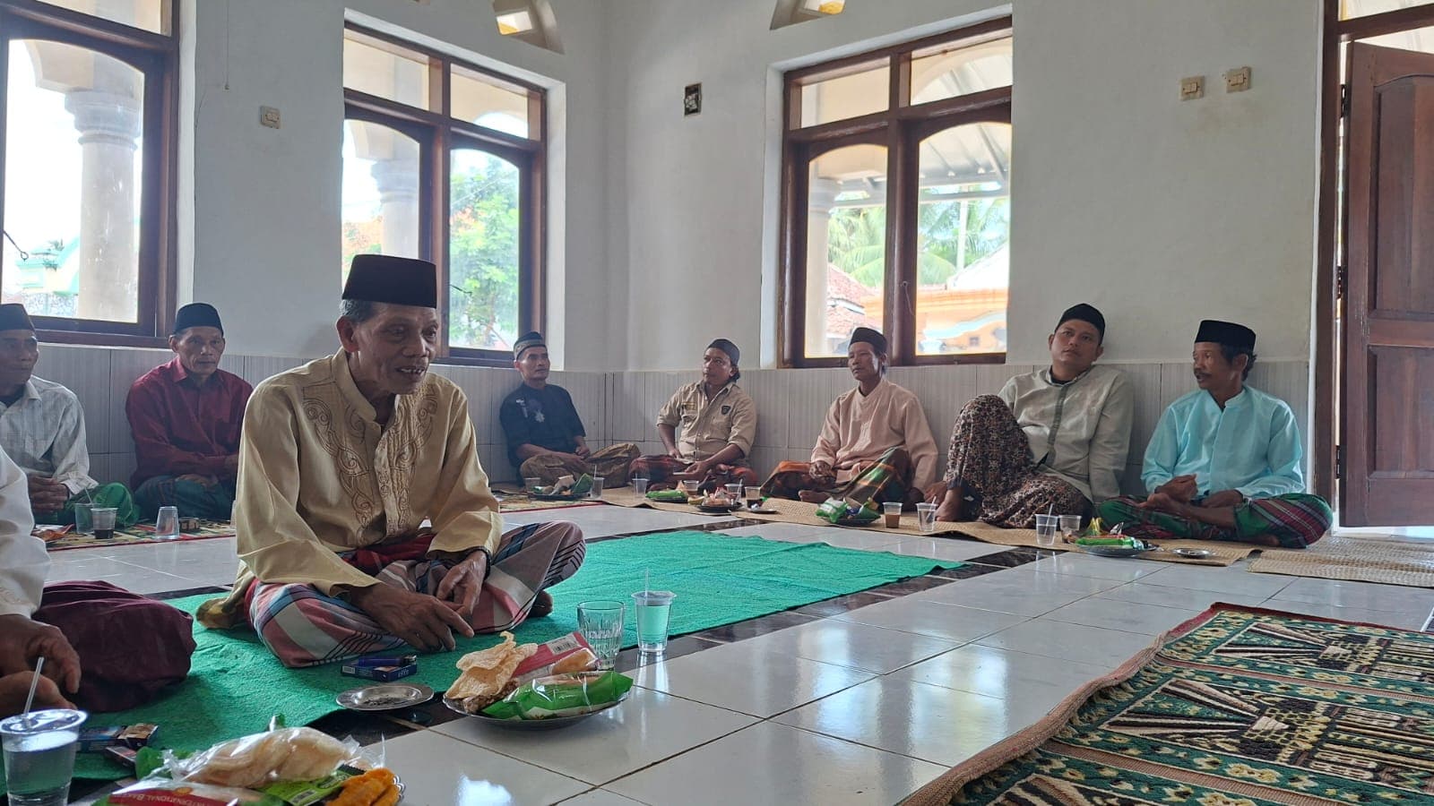 Warga duduk melingkar dalam pengajian di masjid desa.