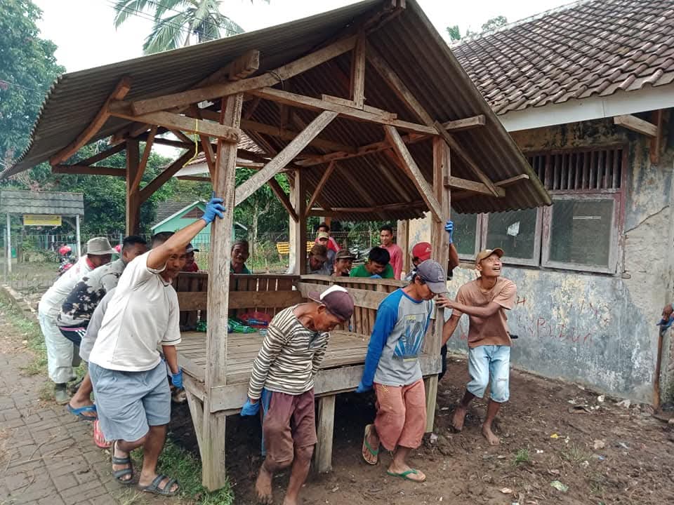 Warga Desa Tembong bergotong royong memindahkan saung bersama-sama.