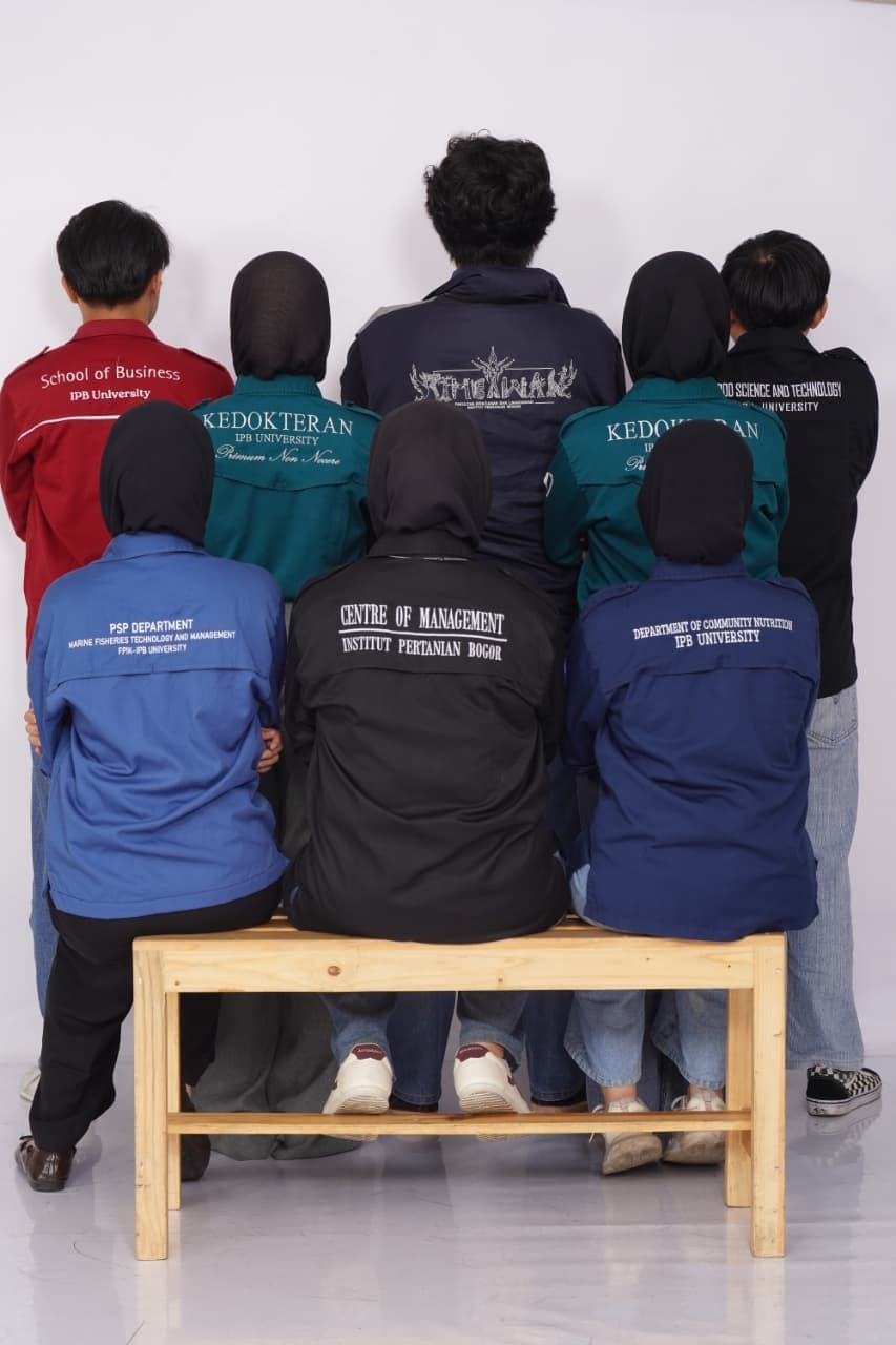 Delapan anggota Tim Tempura difoto dari belakang, mengenakan jaket almamater fakultas masing-masing di IPB University.