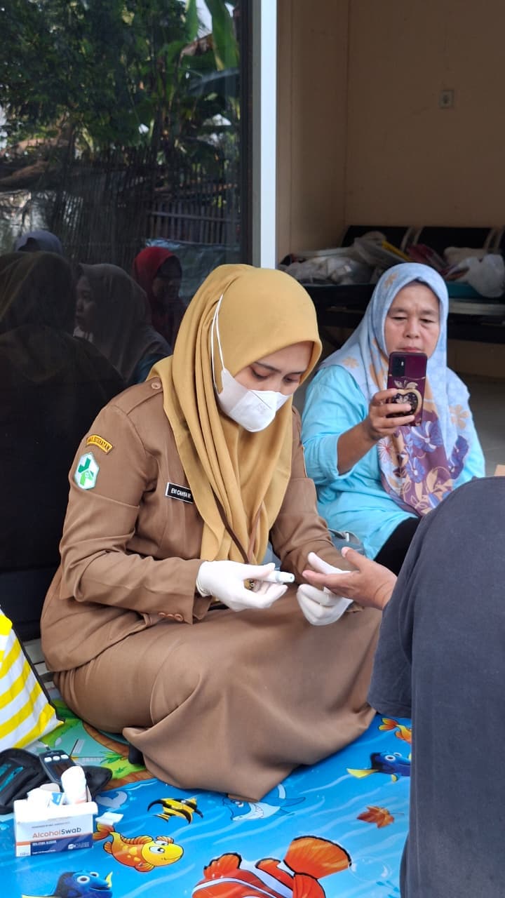 Pemeriksaan kesehatan warga oleh bidan desa dalam kegiatan Posyandu.