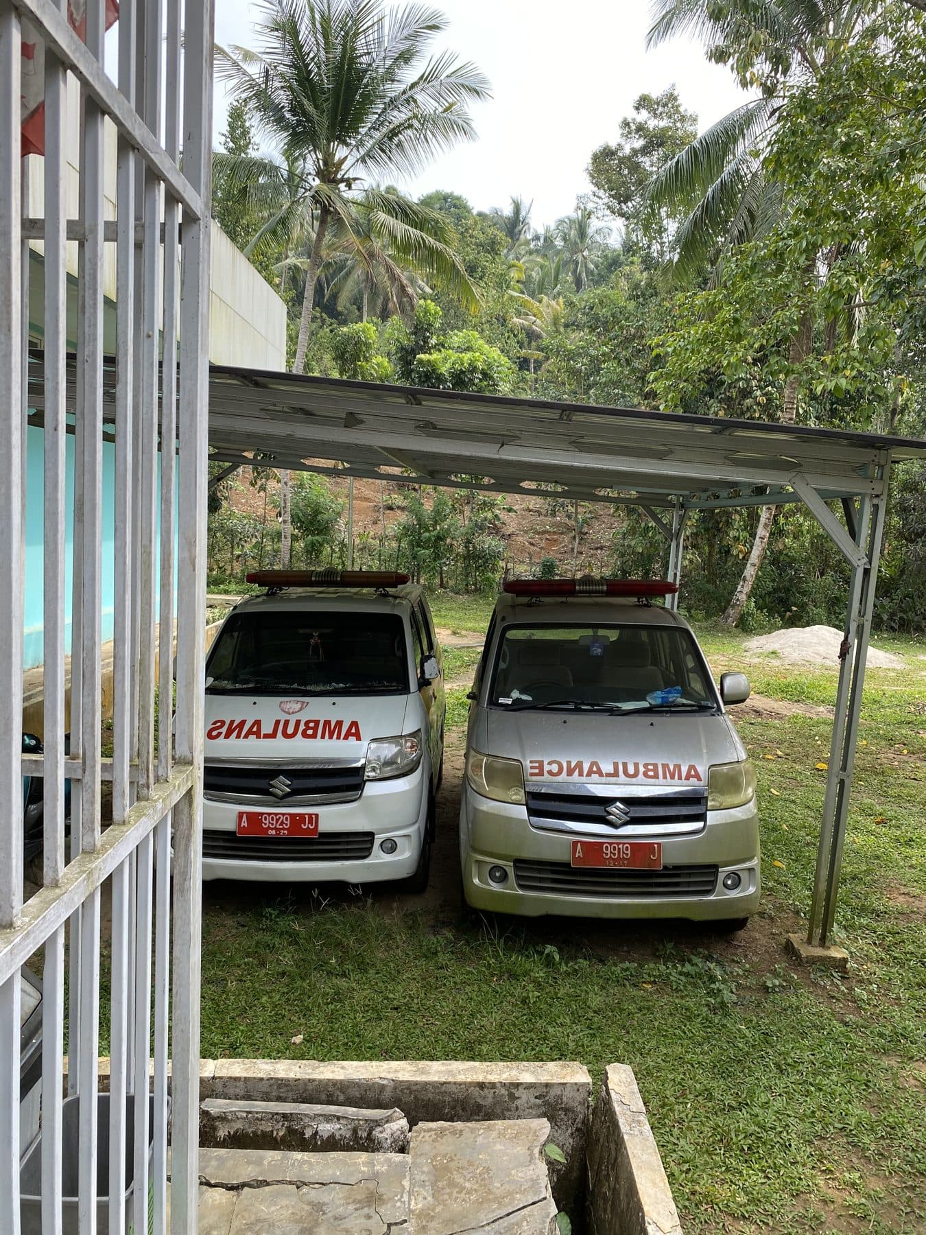 Dua ambulans Puskesmas Carita terparkir di bawah kanopi.
