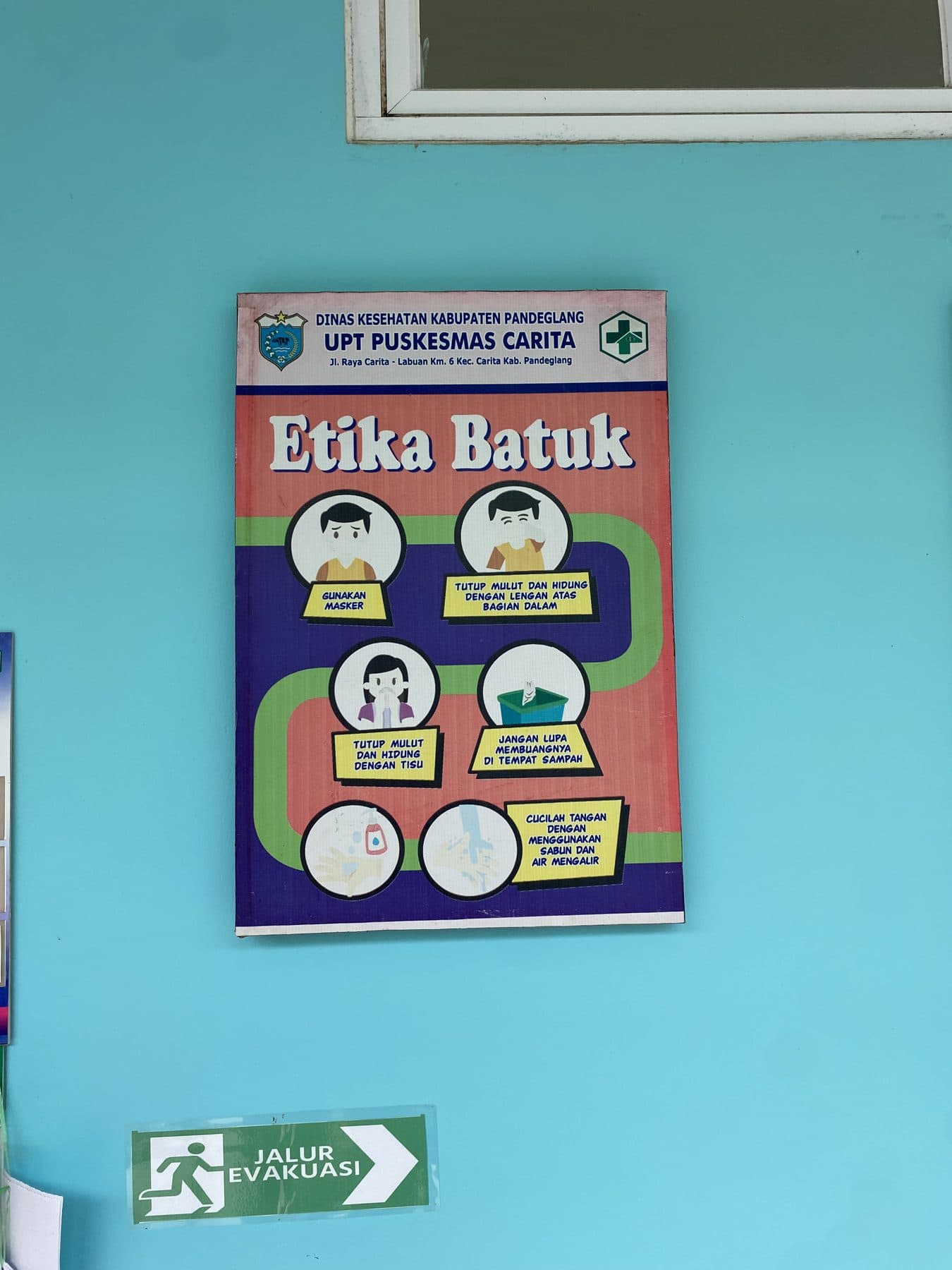 Poster etika batuk yang terpasang di dinding Puskesmas Carita.