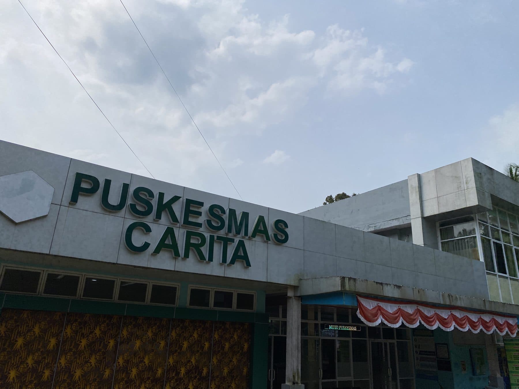 Gedung UPT Puskesmas Carita dengan papan nama di Desa Tembong.